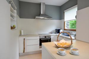a kitchen with a basket of bread and two cups on a counter at Eva's house in Ivanec