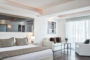 a bedroom with a bed and a couch and a chair at Lesante Classic, a member of Preferred Hotels & Resorts in Tsilivi