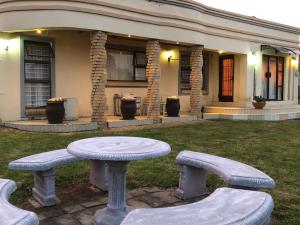 a table and benches in front of a house at Reemaros Guest House in Margate