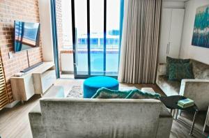 - un salon avec un canapé et une grande fenêtre dans l'établissement Matrix Luxury Apartments Century City, Cape Town, au Cap