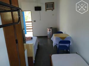a room with a bed and a table and chairs at Recanto da Nina in Maresias