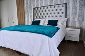 a bedroom with a large bed with a blue blanket at Matrix Luxury 2 bedroom Apartments Century City, Cape Town in Cape Town +6 photos
