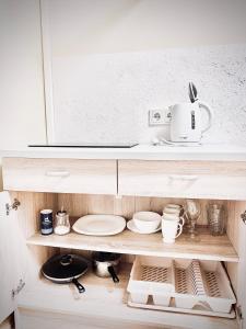 une armoire avec des assiettes et de la vaisselle en haut de celle-ci dans l'établissement Jazz Time Studio, à Birštonas