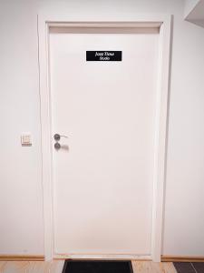 eine weiße Tür mit einem Schild drauf in der Unterkunft Jazz Time Studio in Birštonas