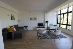 uma sala de estar com um sofá e cadeiras em Treetops Lisbon Apartment em Lisboa