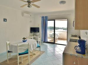 a kitchen with a table and a dining room at Apartments Eufemija in Rab