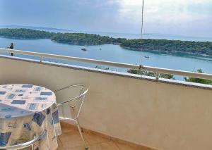 a balcony with a table and a view of a river at Apartments Eufemija in Rab