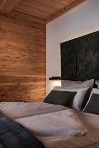 a bedroom with two beds and a wall with wood at Ferienhaus In den Bergen in Oberammergau