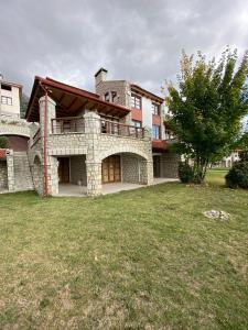 a large house with a grass yard in front of it at Arachova Vip smart chalet-Villa Eva 1 in Arachova