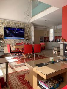a living room with red chairs and a tv on a stone wall at Arachova Vip smart chalet-Villa Eva 1 in Arachova