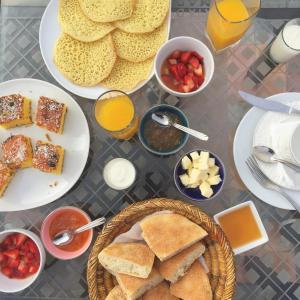 una mesa con platos de comida y bebida para el desayuno en Riad Les Roches Todra, en Tinerhir