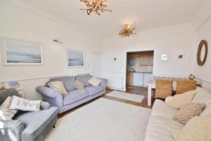 a living room with two couches and a table at Springhill House in Swanage