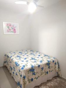 1 dormitorio con 1 cama con sábana floral en Bela casa, en Arraial do Cabo