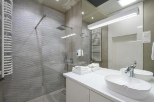 łazienka z umywalką i przeszkloną kabiną prysznicową w obiekcie Exclusive Trendy Apartments w Warszawie