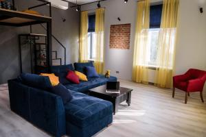 a living room with a blue couch and a table at LVIV OPERA HEAVEN in Lviv