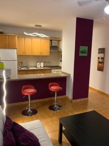 a kitchen with two red stools in a living room at Apartment Ocean Park in Adeje