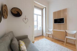 un salon avec un canapé et une chambre avec une fenêtre dans l'établissement LovelyStay - Quiet & Modern Loft minutes away from iron bridge, à Porto