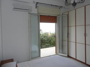 a bedroom with a sliding glass door with a balcony at Leonardo in Capaci