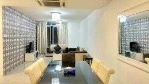a living room with a table and a couch at Taragon Putrie Bintang suites in Kuala Lumpur