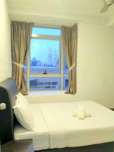 - une chambre avec un lit et une fenêtre avec vue dans l'établissement Taragon Putrie Bintang suites, à Kuala Lumpur
