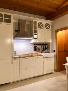 a kitchen with white cabinets and a stove at Casa Nina in Andalo