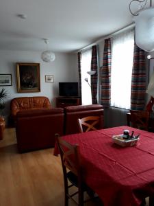 a living room with a red table and a couch at Le Quai 2 in Strasbourg