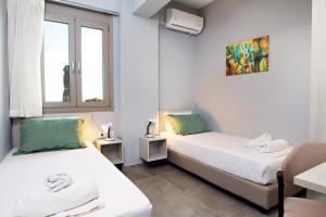 two beds in a room with two windows at Villa Aias in Plakias