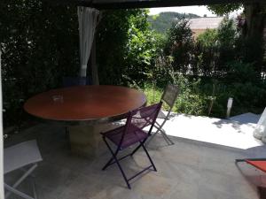 - une table en bois et 2 chaises sur la terrasse dans l'établissement entre mer et montagne, à Peyroules 11 autres photos