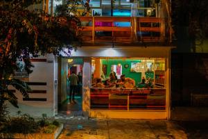 a group of people sitting at a restaurant at night at Nativus Art Hostel in San José