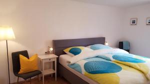 1 dormitorio con 1 cama con almohadas azules y amarillas en Ferienwohnung zur Seepromenade, 100m vom Bodensee en Überlingen