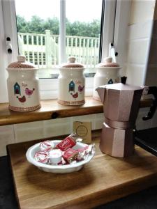 a table with three crock pots and a plate of food at Carnowen Cottage in Ringsend