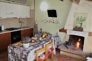 a kitchen with a table with a fireplace in it at Medieval Village of Pacentro in Pacentro