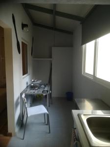 eine Küche mit einem Tisch, Stühlen und einem Waschbecken in der Unterkunft Cc39- Q5 in Funchal