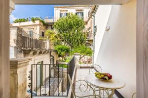 a balcony with a table and a bowl of fruit at Modica for Family - Rooms and Apartments in Modica