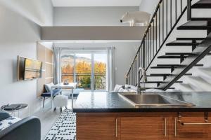 una cocina con fregadero y una escalera en INITIAL - L'OURS - Mont-Sainte-Anne, en Beaupré