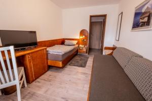 een woonkamer met een bank en een flatscreen-tv bij Hotel Klosterhof in Wehr