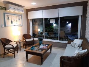 Una sala de estar con un sofá y sillas y una mesa. en Hotel Casarão Pitangueiras, en Guarujá