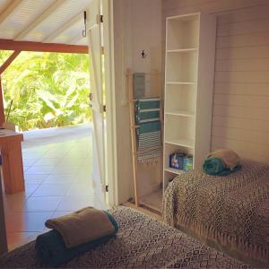 a bedroom with a bed and a door to a porch at Coin Paradis in Anse-Bertrand