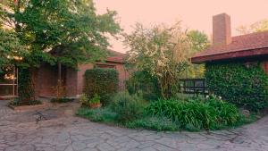 a brick house with a garden in front of it at Nomeolvides in Tandil
