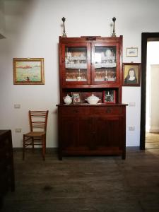 een houten kast in een kamer met een stoel bij Casa Cortes in Desulo