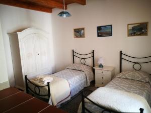 een slaapkamer met 2 bedden, een bureau en een tafel bij Casa Cortes in Desulo