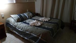 a bedroom with a bed with two pillows on it at Hotel Nuevo Fatica in Villa Carlos Paz