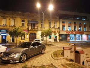 een auto die 's nachts voor een gebouw geparkeerd staat bij Apartament JOSEFIN in Timişoara