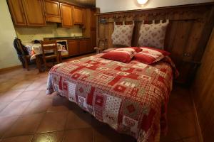 Un dormitorio con una cama con almohadas rojas. en La Belette, en La Thuile