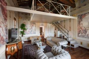 una sala de estar con sofás y una escalera. en Domus Nannini SPA - Palazzo Nannini, en Siena