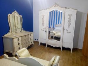 a bedroom with white furniture and a dresser and a mirror at Villa sullo stretto in SantʼAgata