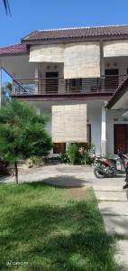 ein Gebäude mit einem Hof mit einem Motorrad, das davor geparkt ist in der Unterkunft Rasti Homestay in Kuta Lombok