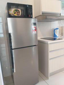 a refrigerator with a microwave on top of it in a kitchen at D Summit Cozy Homestay in Skudai