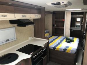 a bedroom with a bed and a microwave at Karumba Point Sunset Caravan Park in Karumba
