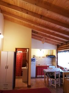 a kitchen and dining room with a table and a refrigerator at Complejo Alma Serrana in Sierra de la Ventana